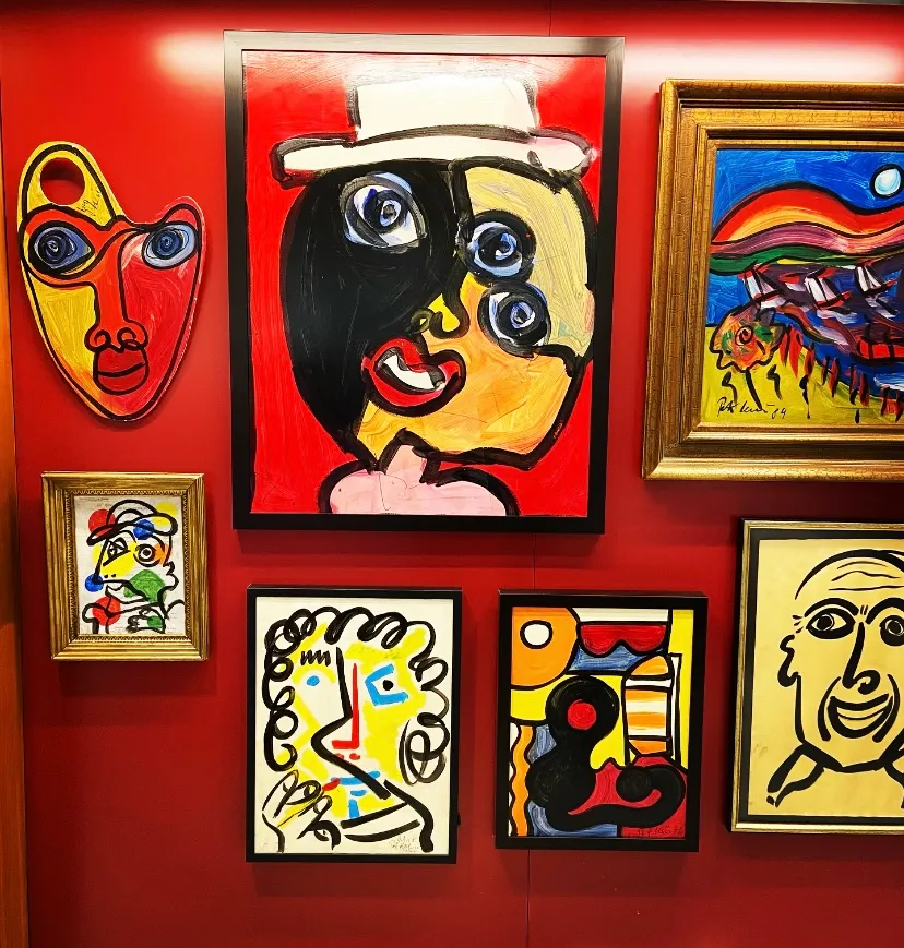Various Picasso-style paintings hanging on wall