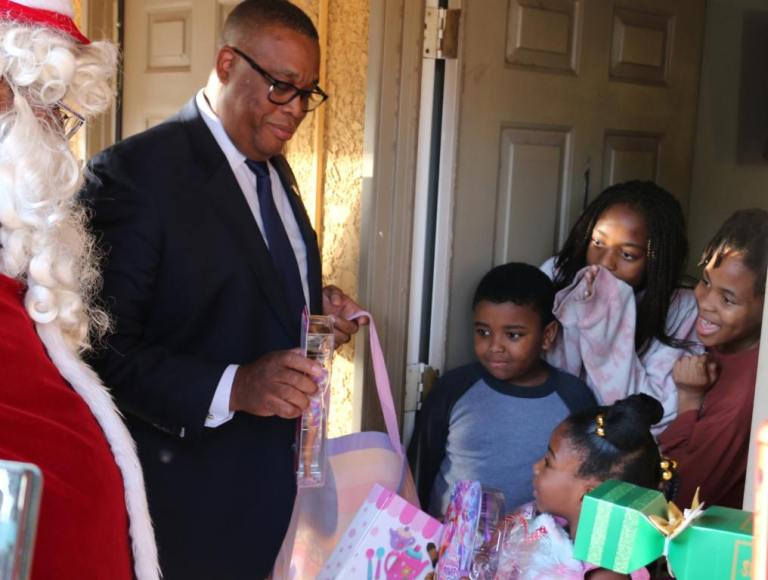 Ward 5 City Councilman Cedric Crear and Thumpa Claus meet Gina's family. Toys are everywhere.